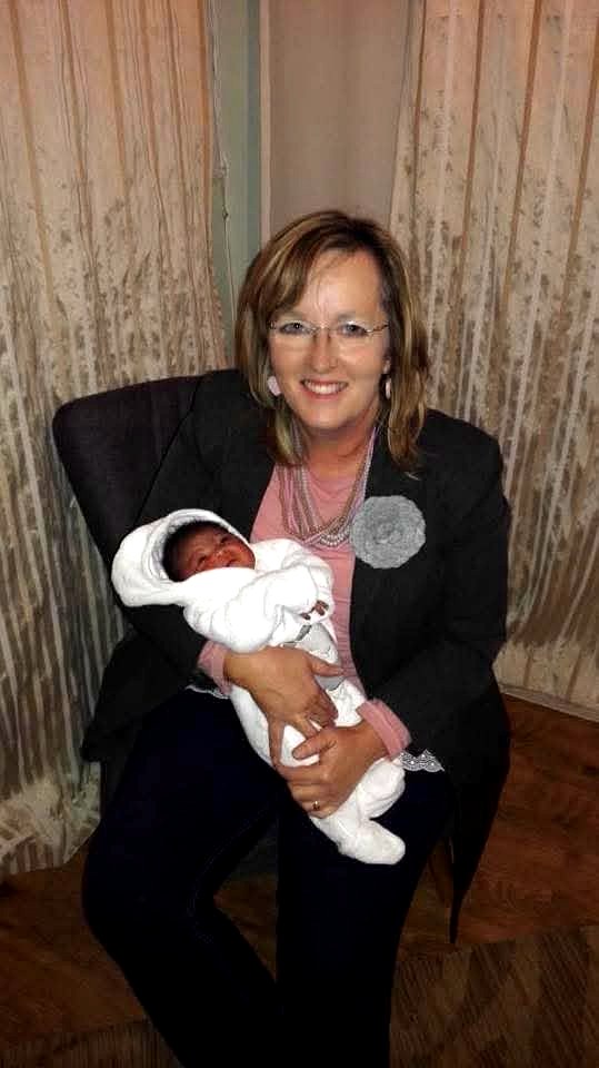 Pauli Koch holding a newborn at Zoé House